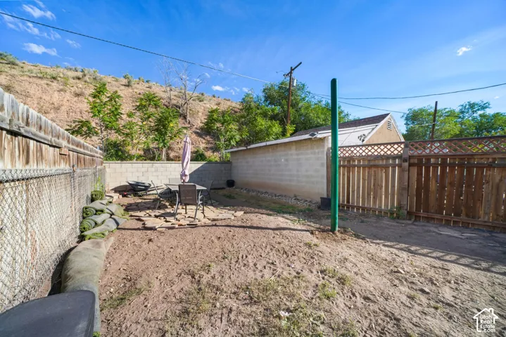 Private outdoor space featuring a paved patio area, wood fencing, and concrete block walls