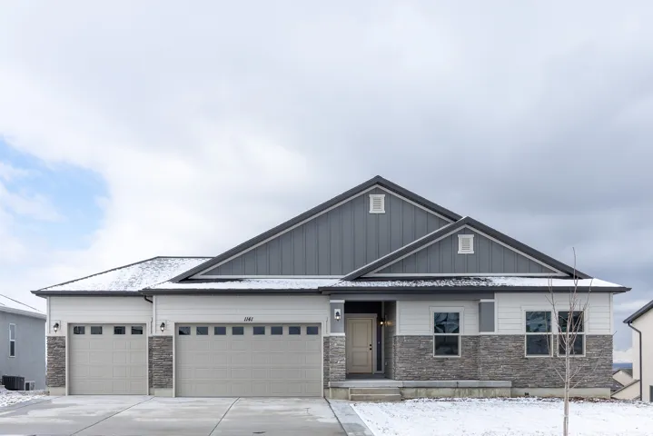 Stone veneer and horizontal siding exterior with a three-car garage and gabled rooflines