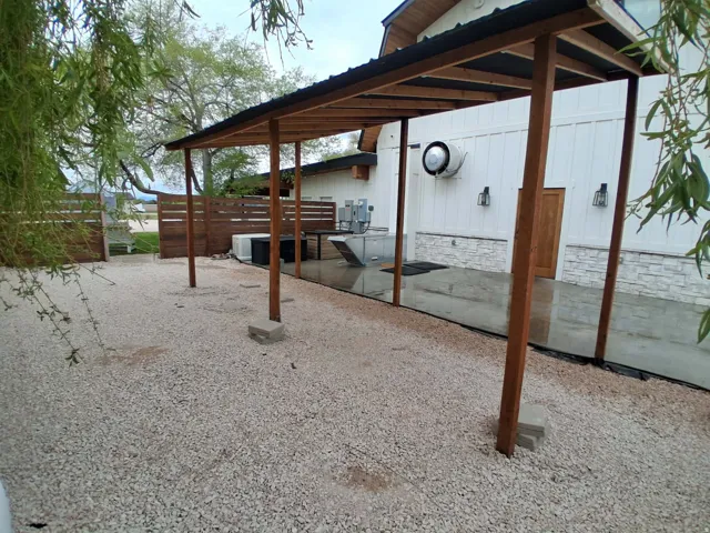 Covered patio structure with wood posts and a black metal roof