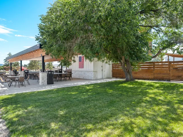 Expansive covered patio with exposed wood beams and string lighting
