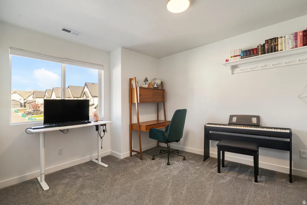 Carpeted room with a large window, white walls, and a built-in wall shelf