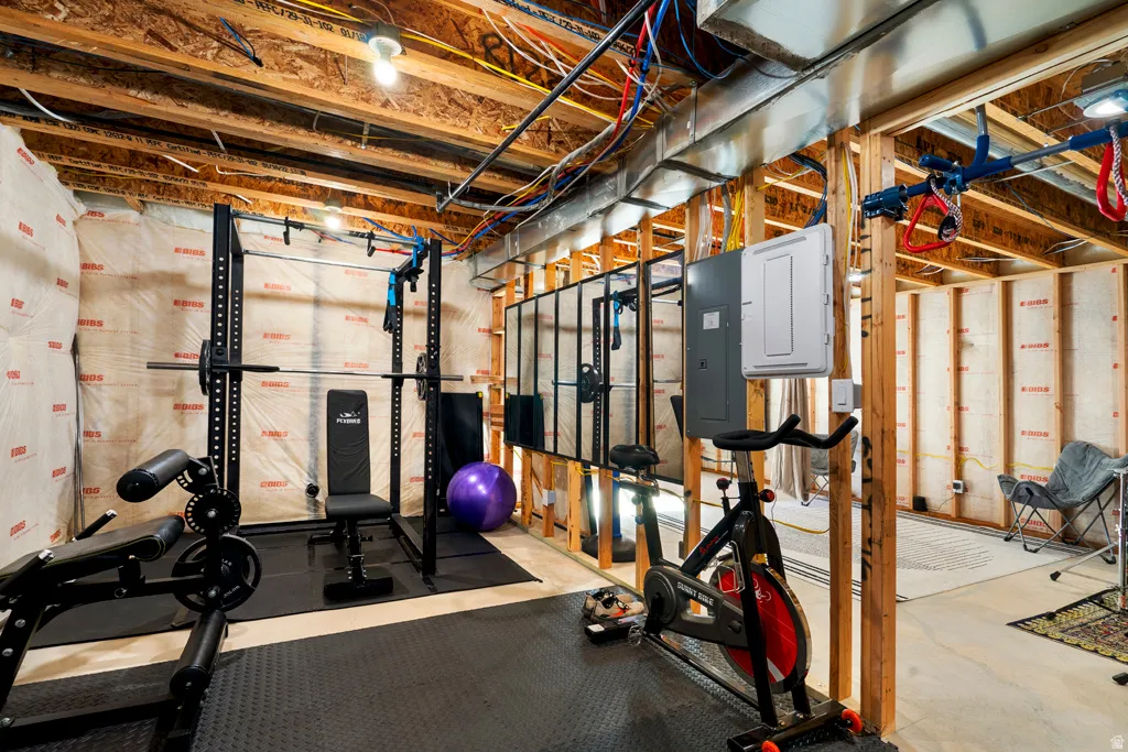 Unfinished basement space featuring exposed wood framing, ceiling joists, and utility access