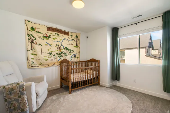 Carpeted room with white walls, a large window, and a ceiling-mounted light fixture