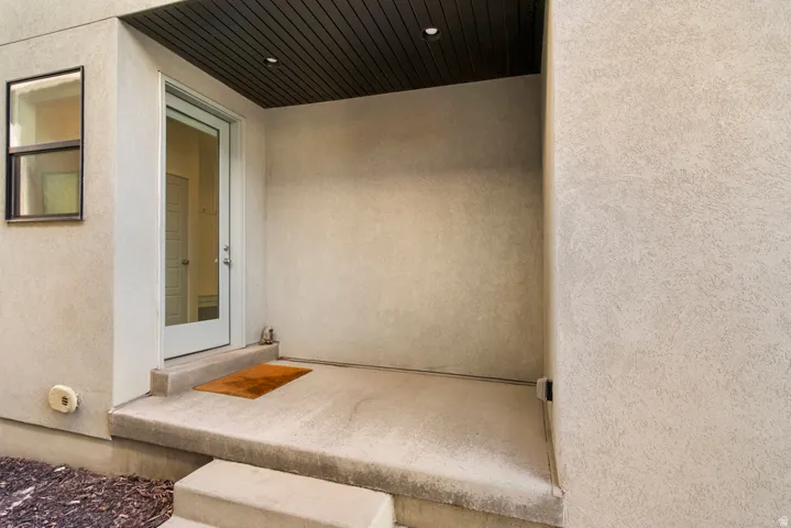 Covered entryway featuring a full-light entry door, recessed ceiling lighting, and stucco exterior finish