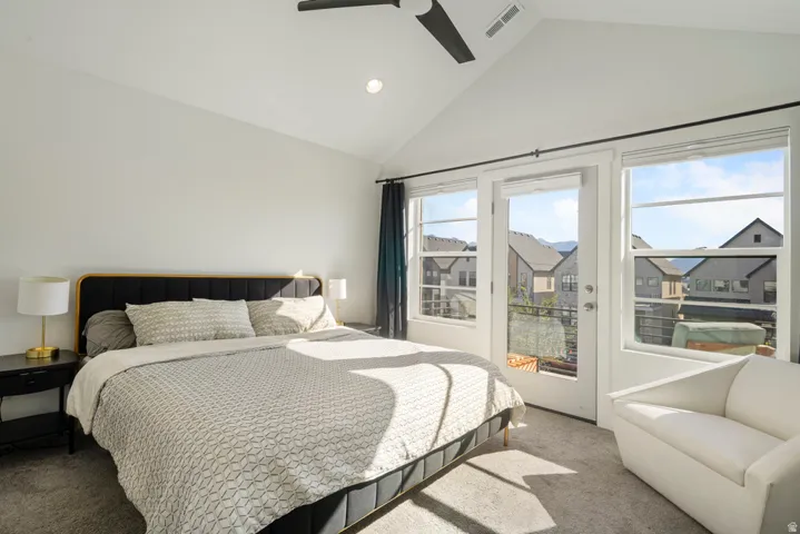 Vaulted ceilings with recessed lighting, ceiling fan, carpet flooring, and a private balcony