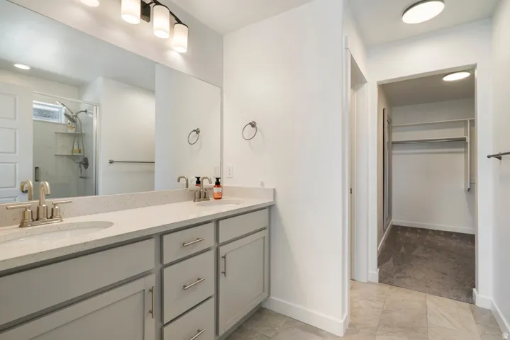 Dual vanity with light-toned countertop, brushed nickel fixtures, and extensive mirror