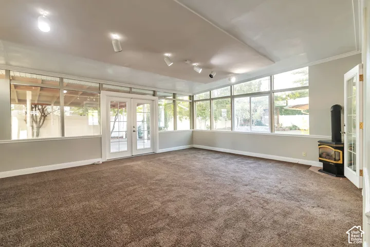 Expansive family/sun room featuring wall-to-wall carpeting, multiple windows, French doors, track lighting, and a built-in stove