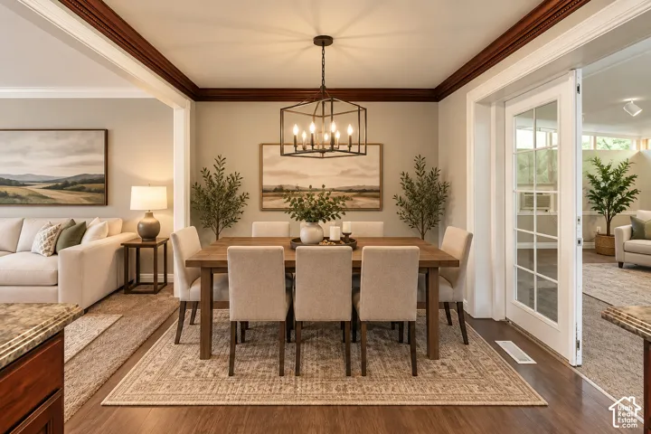 Dining area featuring wood-finish flooring, a linear chandelier, and a decorative ceiling trim