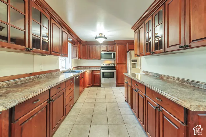 Kitchen with rich wood cabinetry, stainless steel appliances, and tiled flooring
