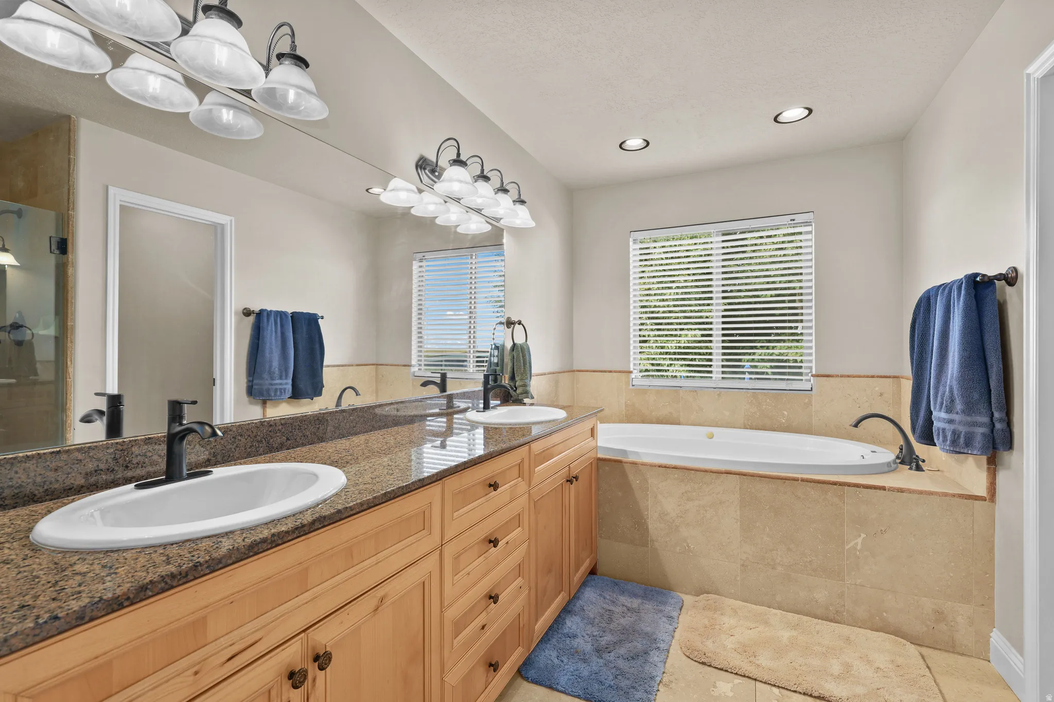 Double vanity with a granite countertop, undermount sinks, and matte black fixtures