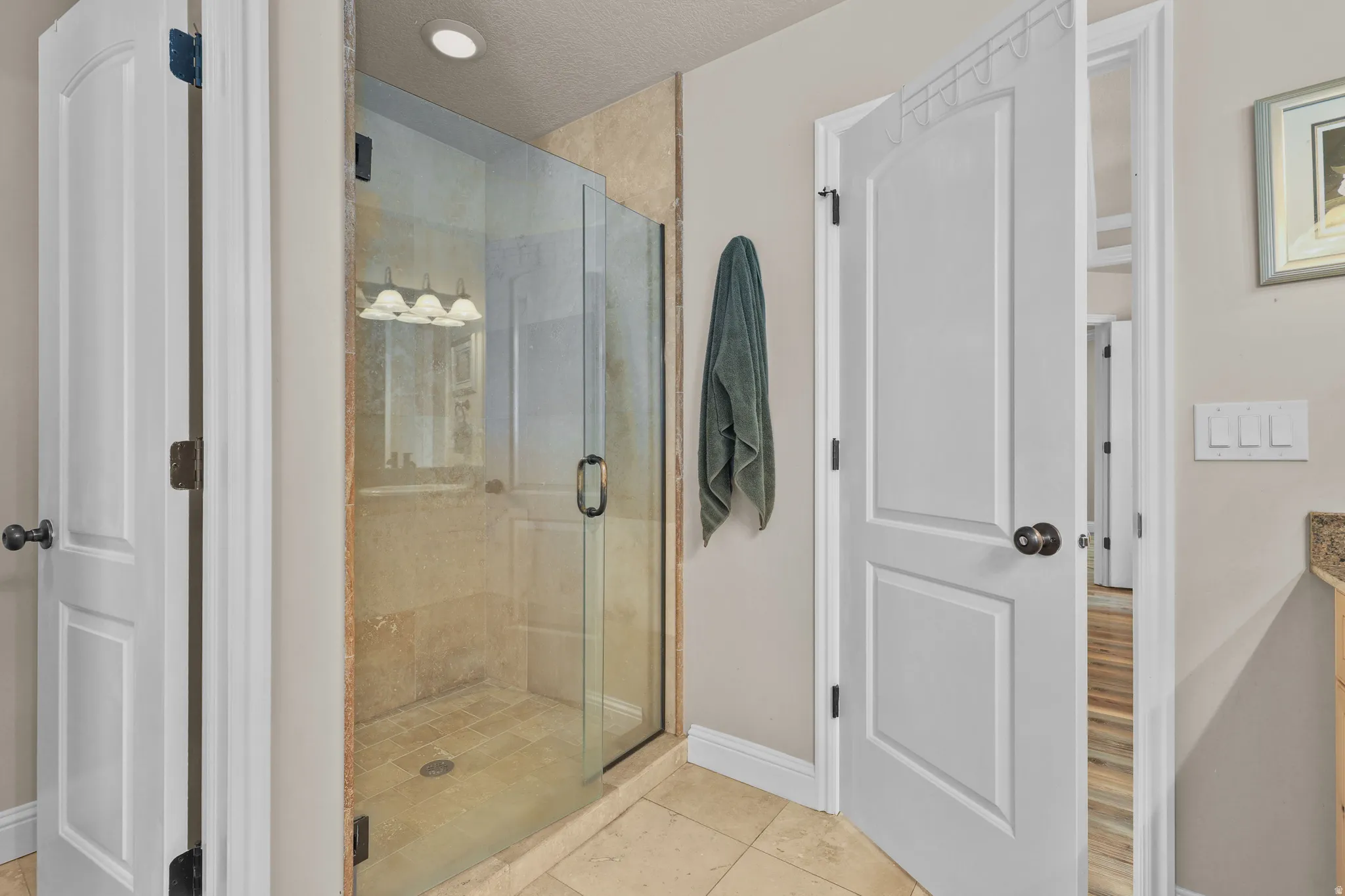 Glass-enclosed shower with a tiled interior and recessed lighting