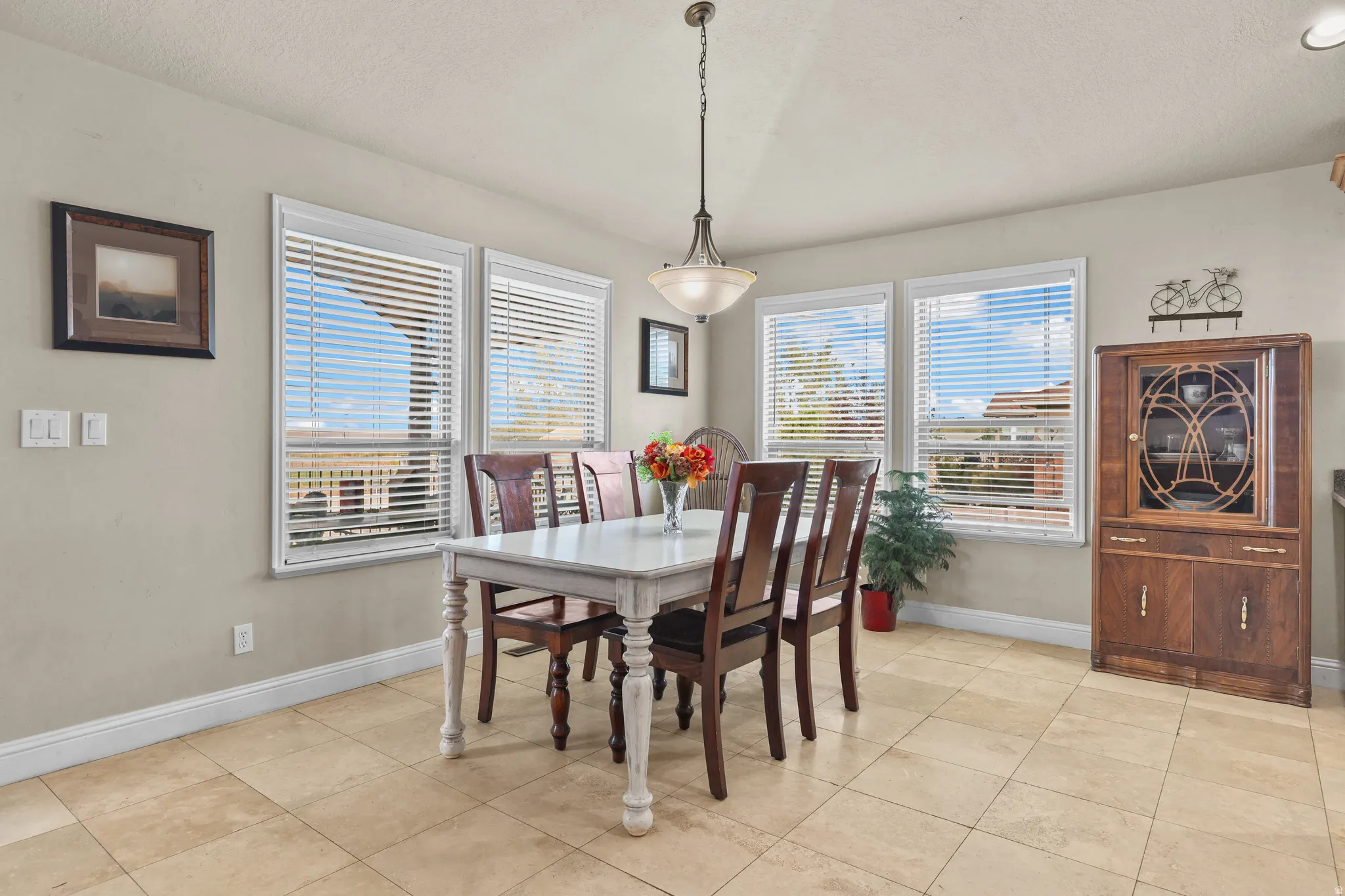 Recessed lighting and a decorative hanging fixture illuminate the space
