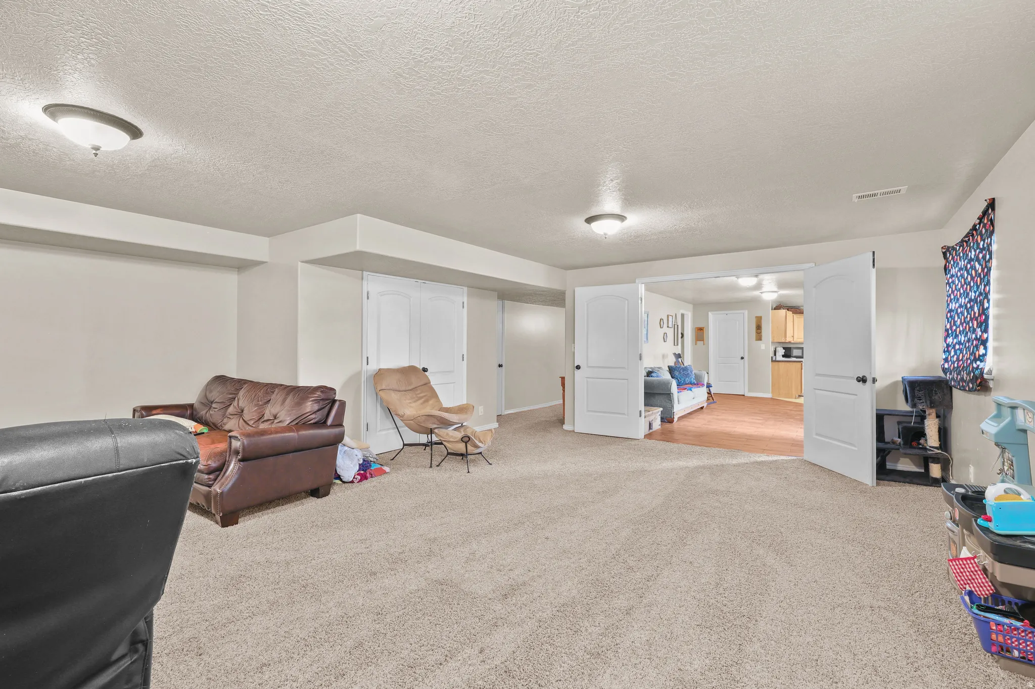 Carpeted living area with recessed lighting and neutral wall tones
