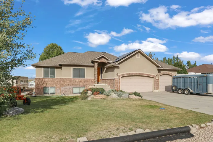 Stucco and brick exterior with a two-car garage and an additional single-car garage