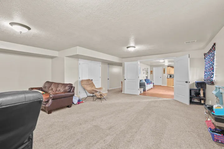 Carpeted living area with recessed lighting and neutral wall tones