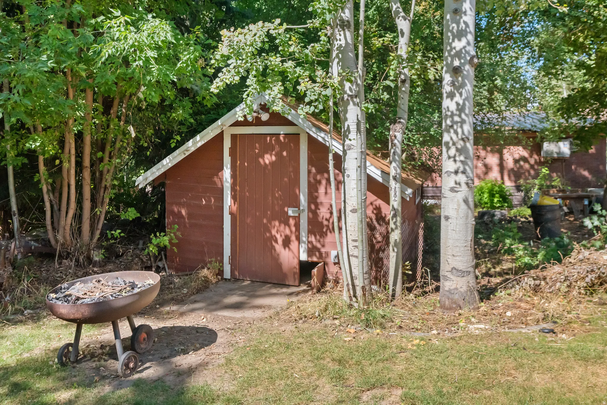 Red-painted shed with a pitched roof and a wooden door