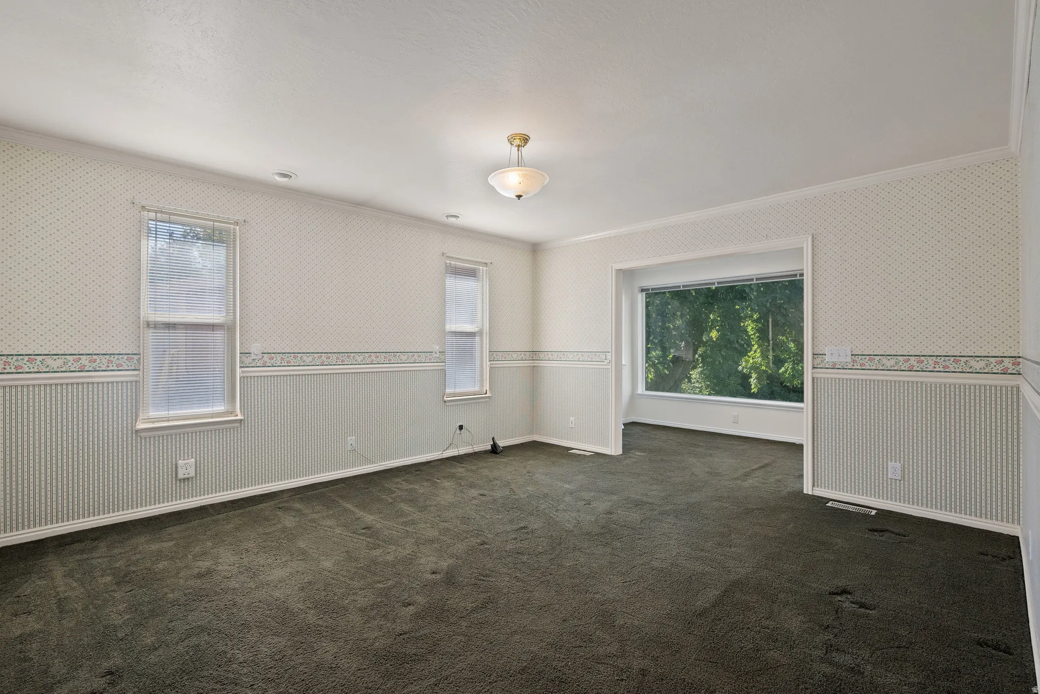 Spacious interior featuring patterned wallpaper, a decorative border, and beadboard paneling