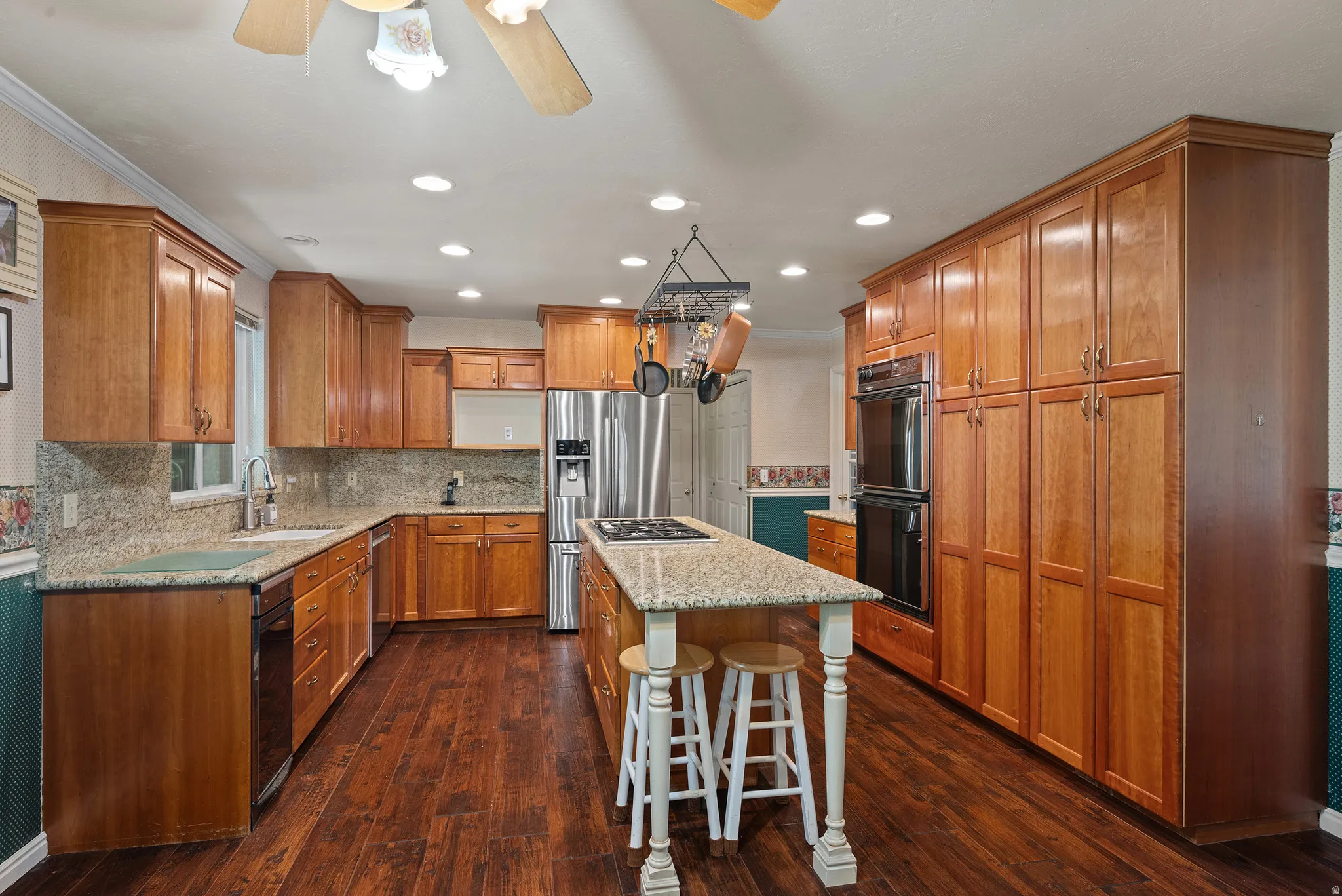 Kitchen featuring wood-finish flooring, recessed lighting, wood cabinetry, granite countertops, and stainless steel appliances