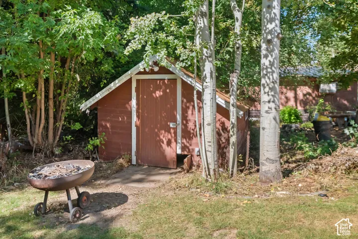 Red-painted shed with a pitched roof and a wooden door