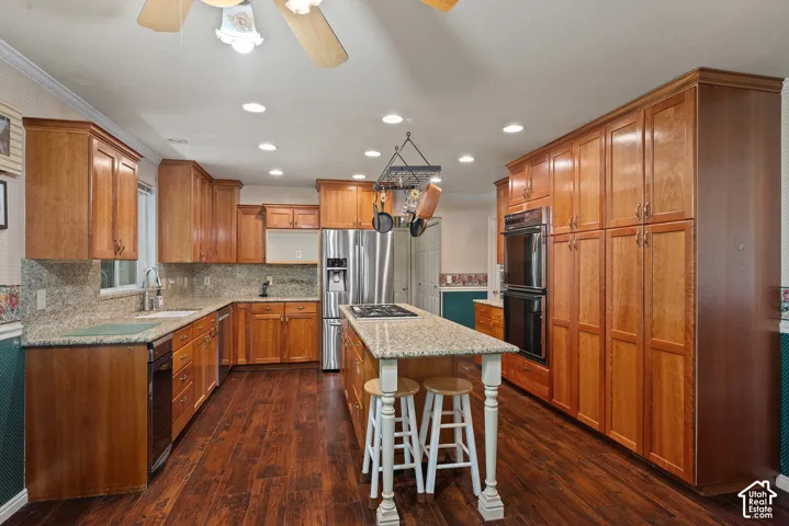 Kitchen featuring wood-finish flooring, recessed lighting, wood cabinetry, granite countertops, and stainless steel appliances
