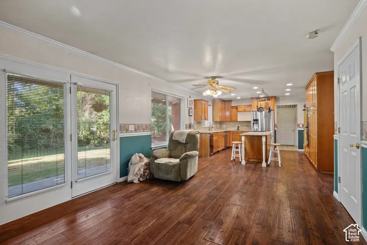 Wood-finish flooring, glass panel doors, recessed lighting, ceiling fan, and wood cabinetry