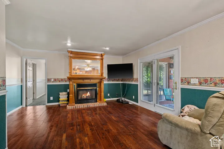 Wood-finish flooring, a brick-surround fireplace with a wood mantel, recessed lighting, and sliding glass doors