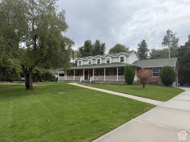 Brick facade with white trim, green roof, and dormer windows