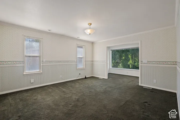 Spacious interior featuring patterned wallpaper, a decorative border, and beadboard paneling