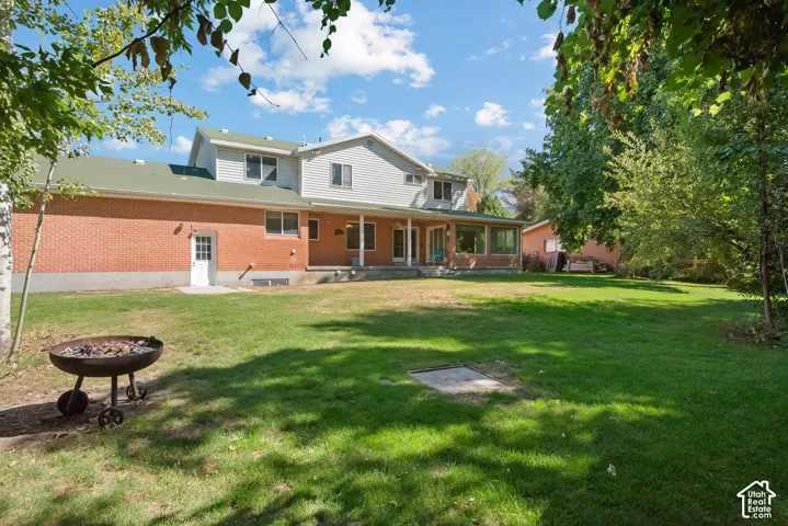 Expansive green lawn with mature trees and a brick and siding exterior