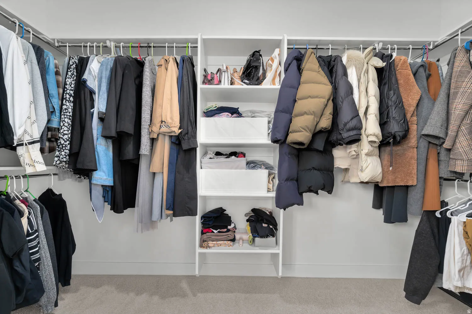 Built-in shelving with hanging rods and neutral wall finish