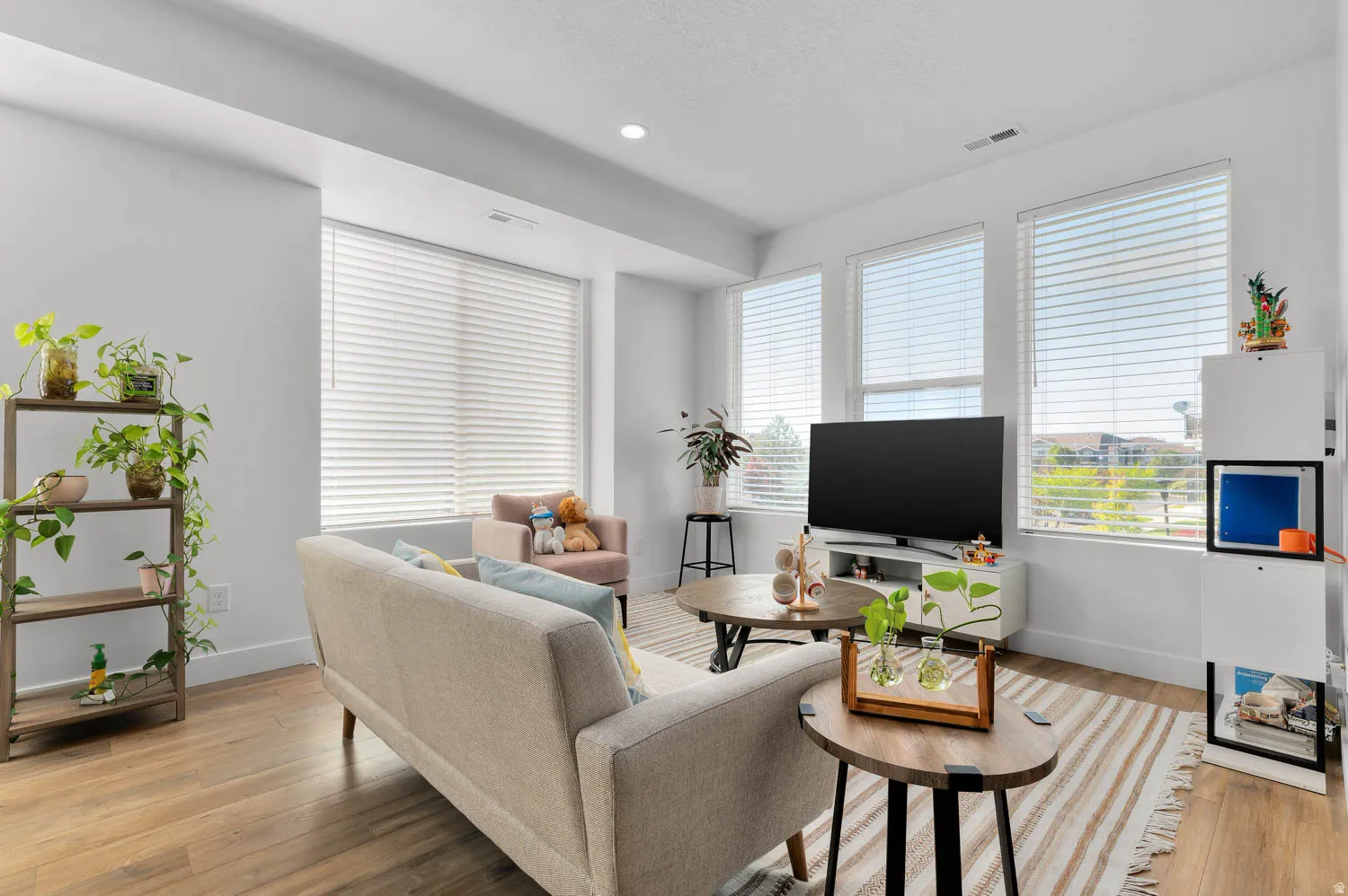 Recessed lighting, wood-finish flooring, and multiple windows with blinds