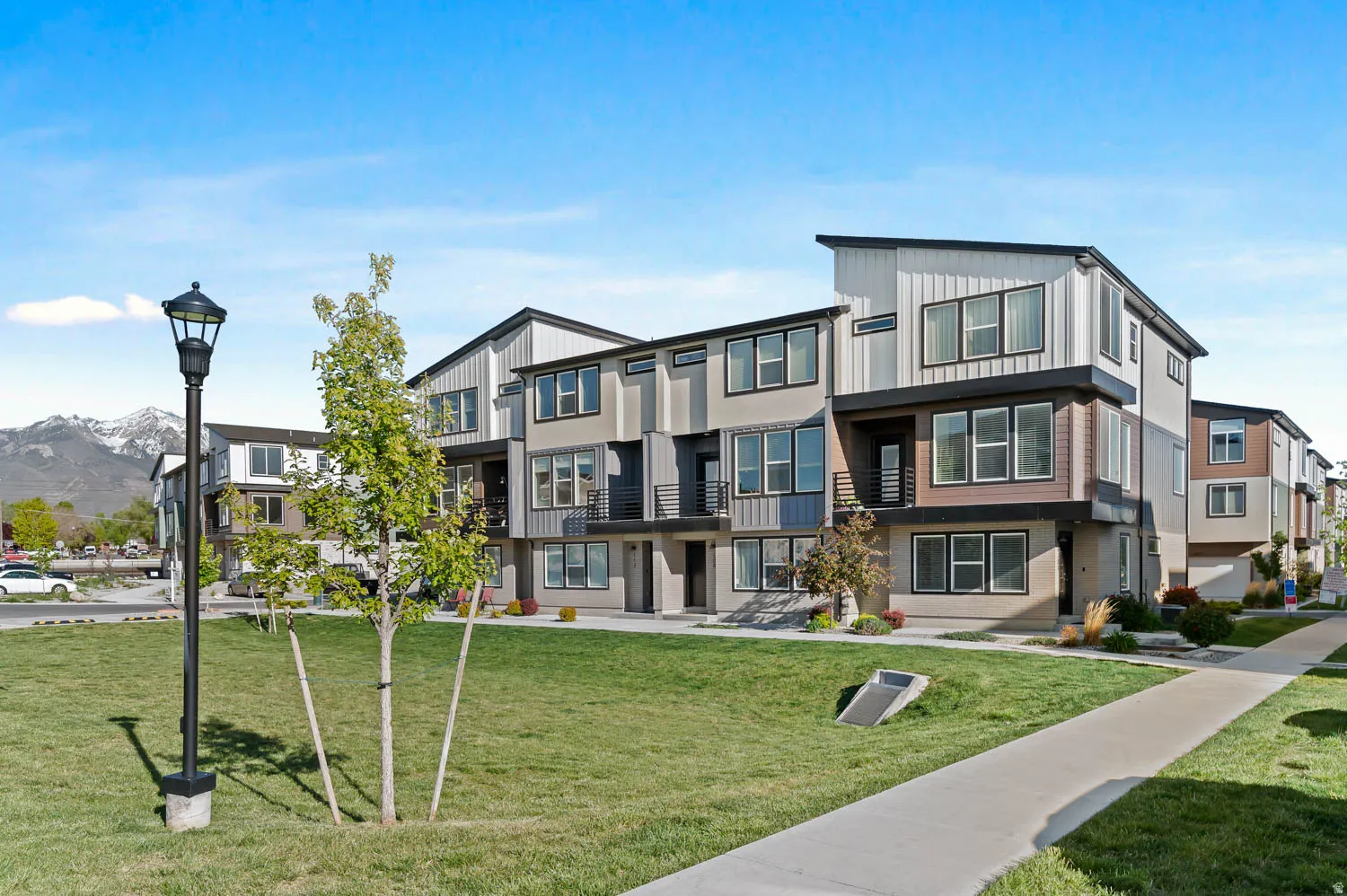 Modern townhome exteriors featuring varied siding materials, balconies, and multiple windows