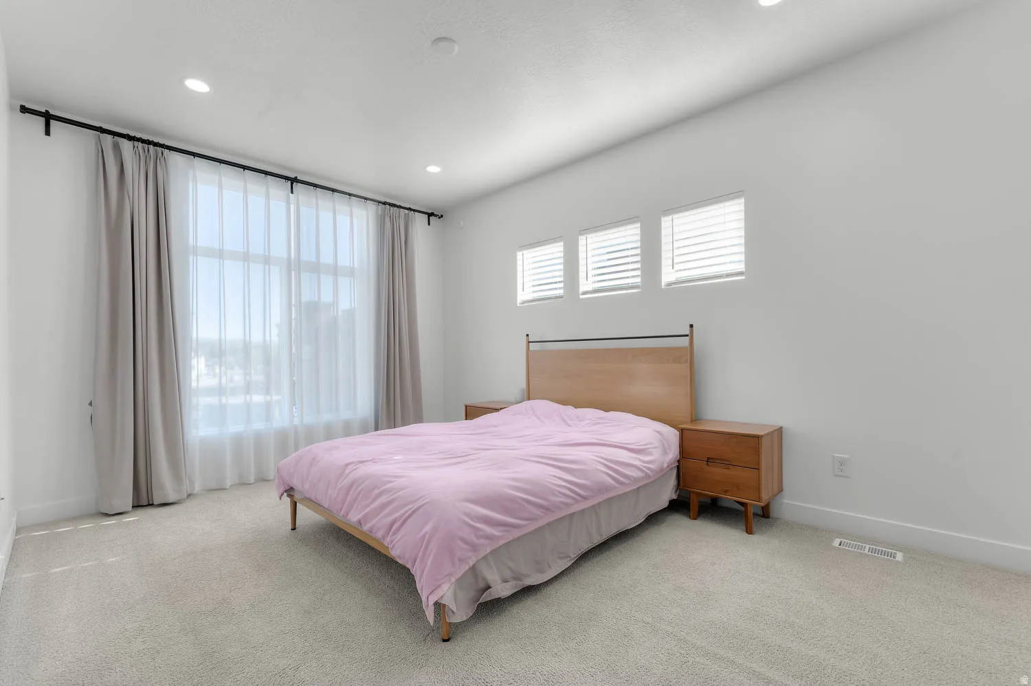 Wall-to-wall carpeting, recessed lighting, and multiple windows with blinds