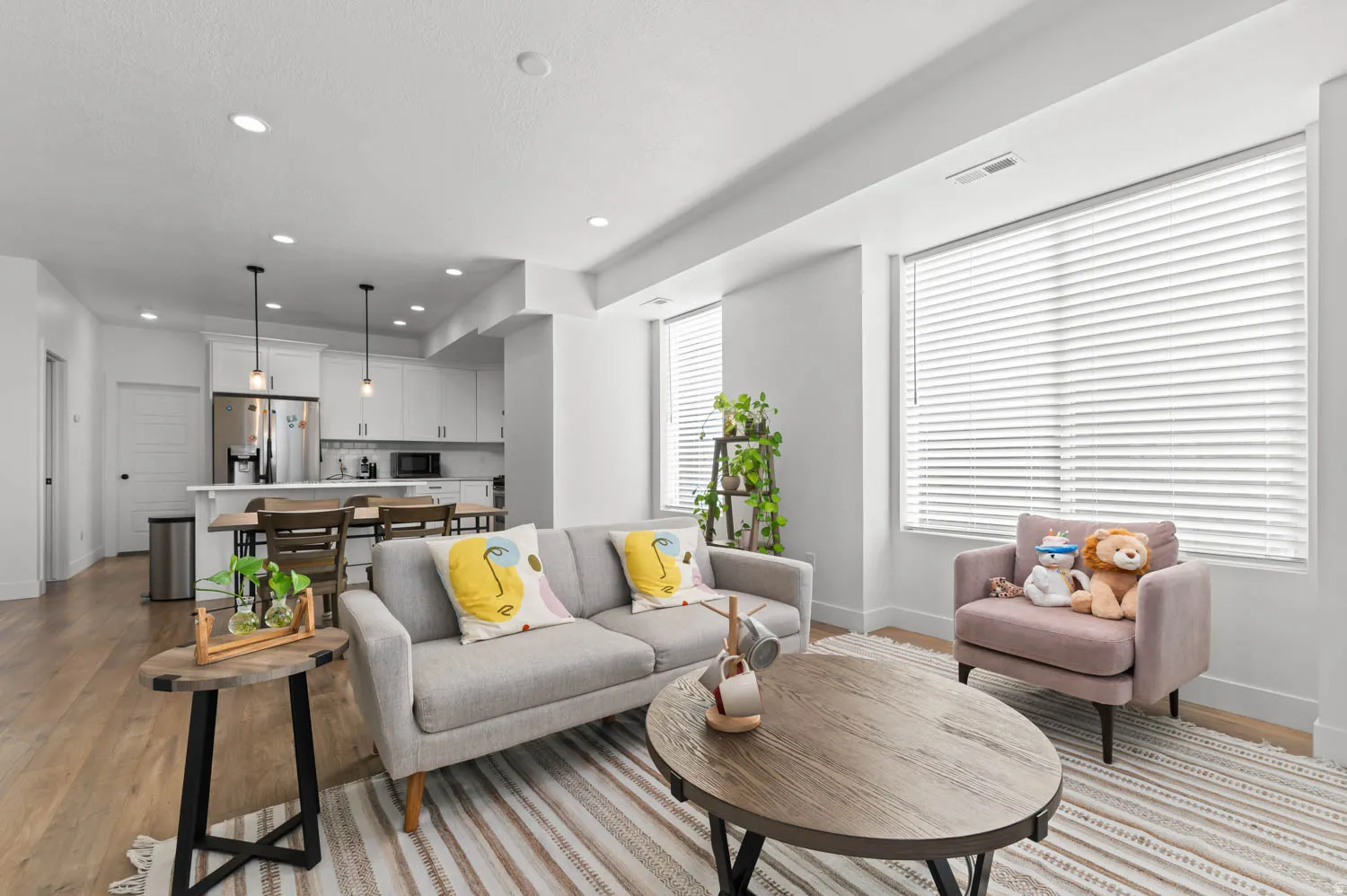 Open-concept living area featuring wood-finish flooring, recessed lighting, and white window blinds