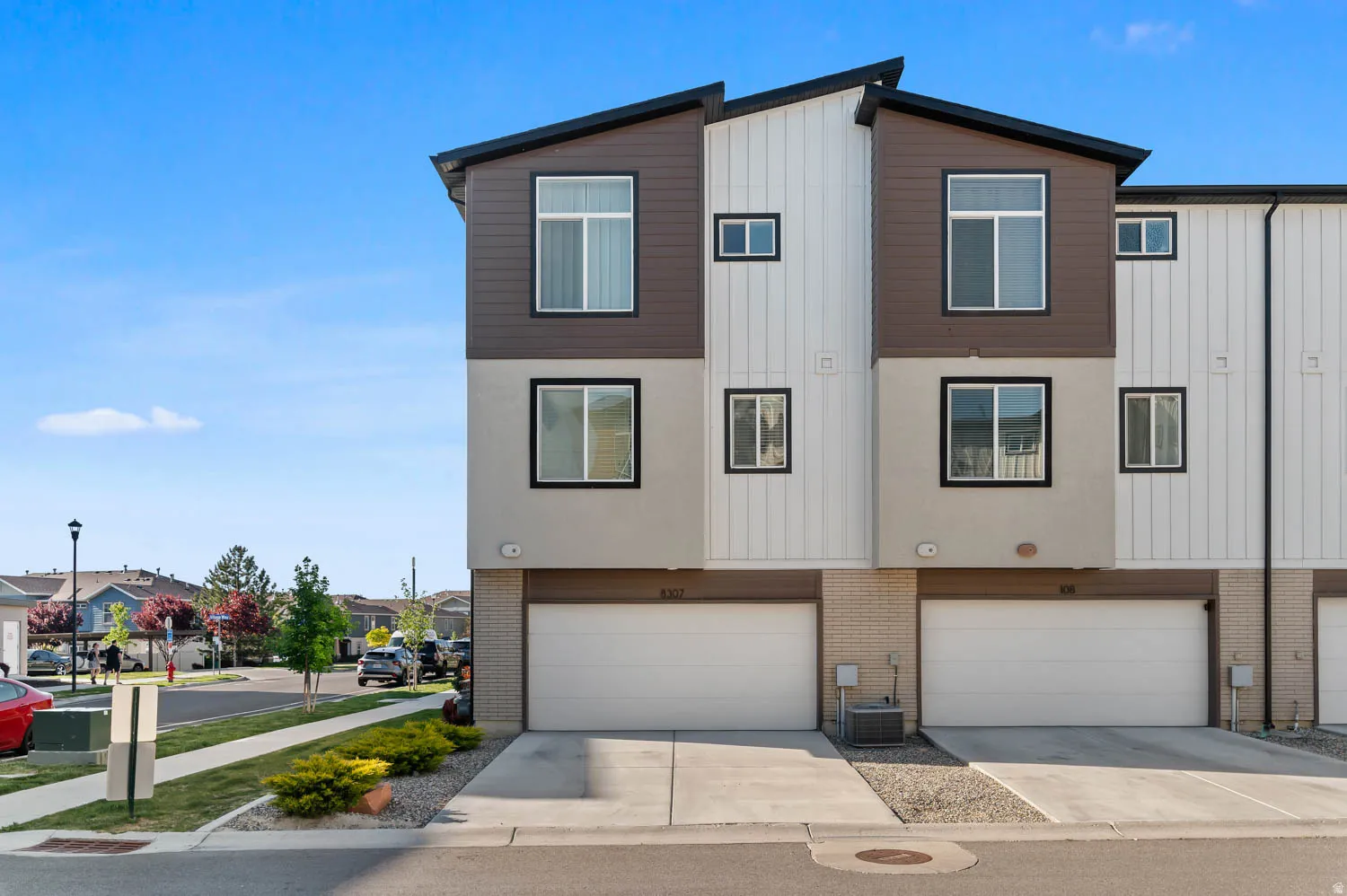 Modern townhome exterior with mixed-material facade, featuring vertical siding and stucco