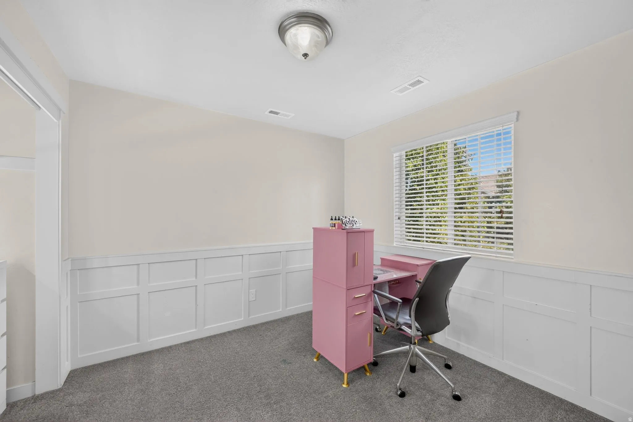 Room featuring wainscoting, a window with horizontal blinds, and a flush mount ceiling light fixture