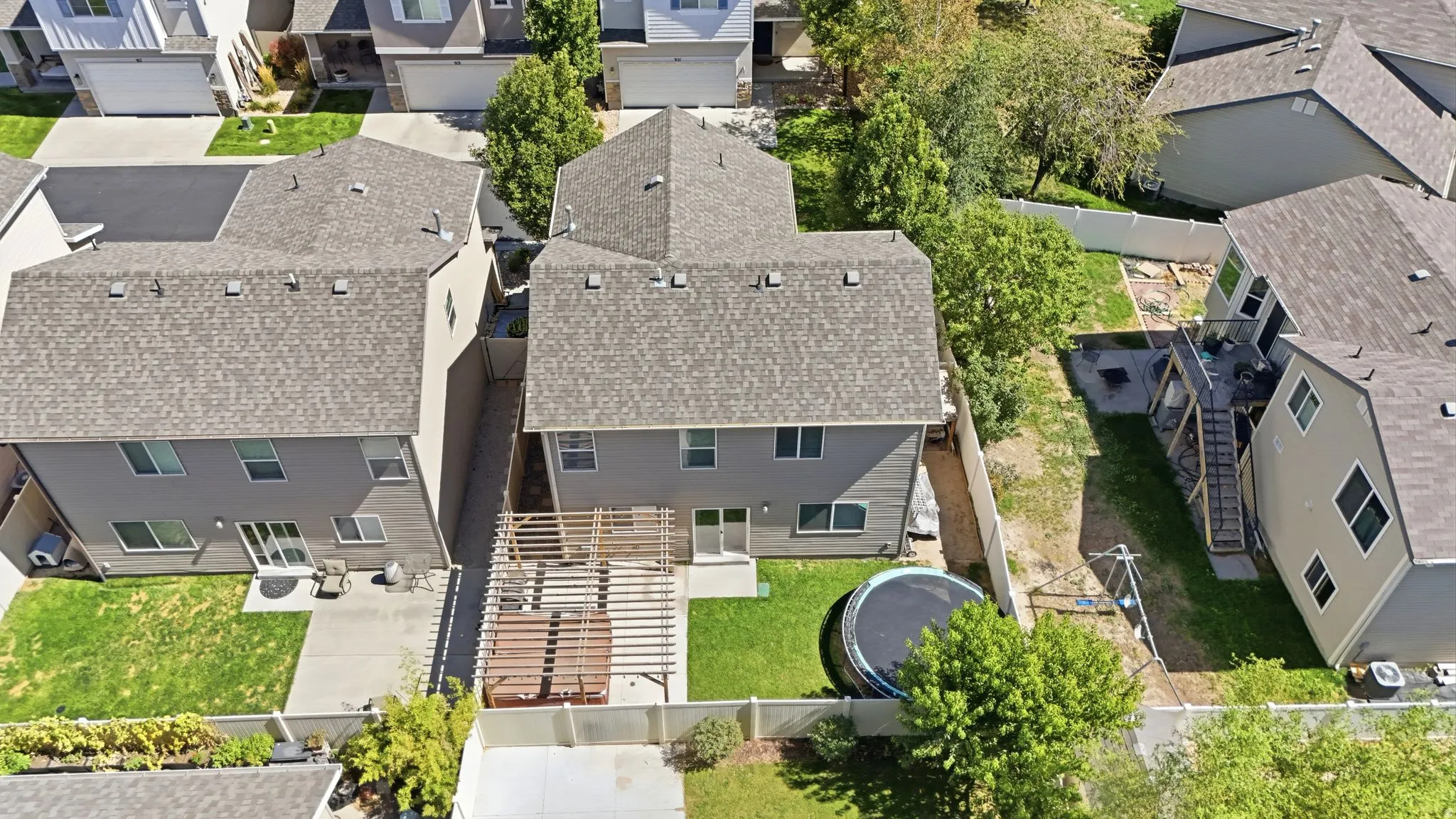 Rear exterior featuring a patio, manicured lawn, and privacy fencing