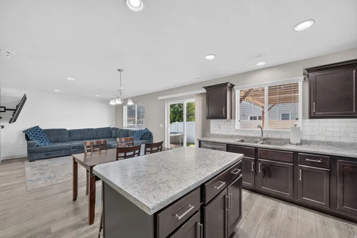 Open-concept living space featuring wood-finish flooring, recessed lighting, and a shiplap accent wall