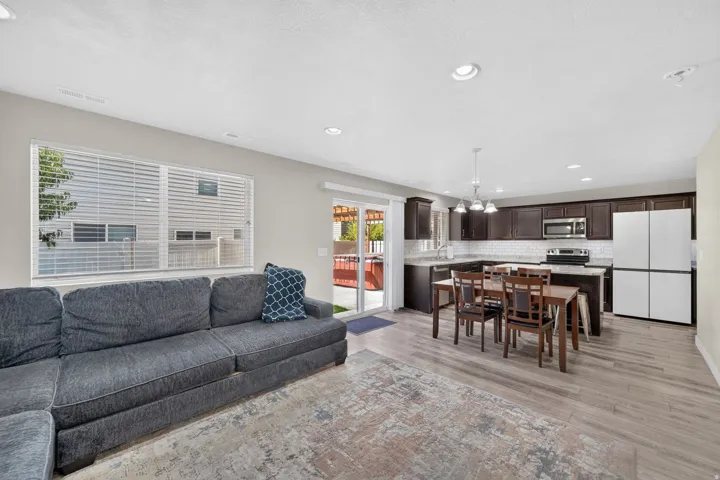 Open concept living area featuring wood-finish flooring, recessed lighting, and a sliding glass door