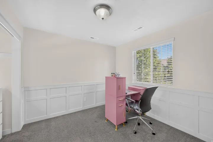 Room featuring wainscoting, a window with horizontal blinds, and a flush mount ceiling light fixture