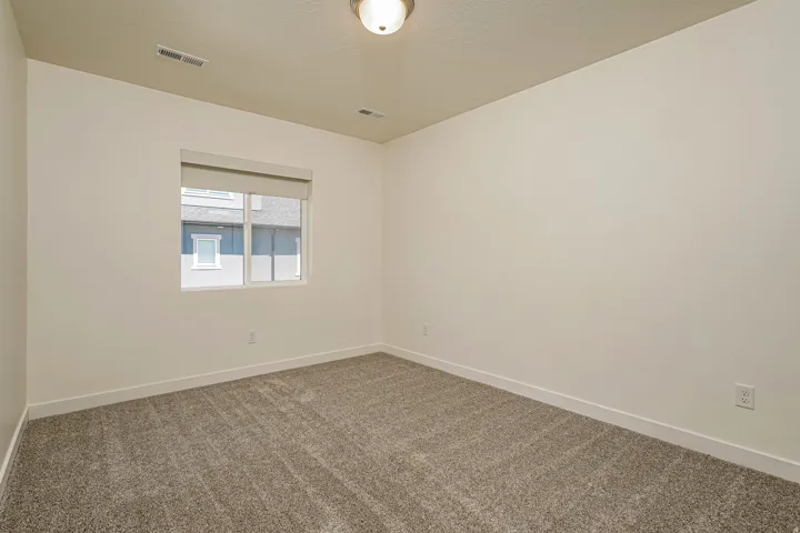 Carpeted flooring, single window with roller shade, overhead light fixture