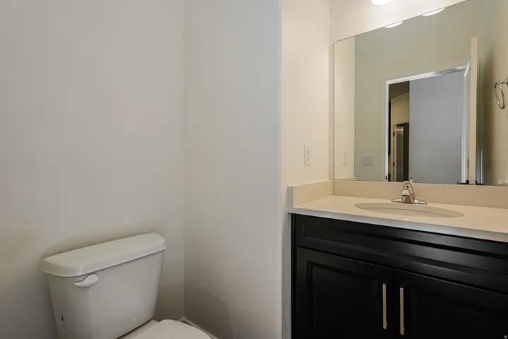 Vanity with dark wood cabinetry, light-colored countertop, and integrated sink