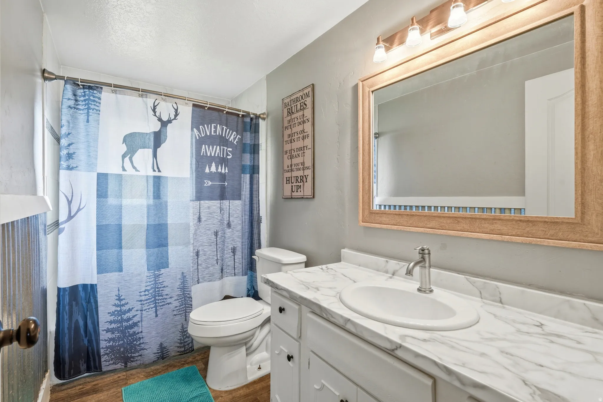 Vanity with a white oval sink, brushed nickel faucet, and marble-look countertop
