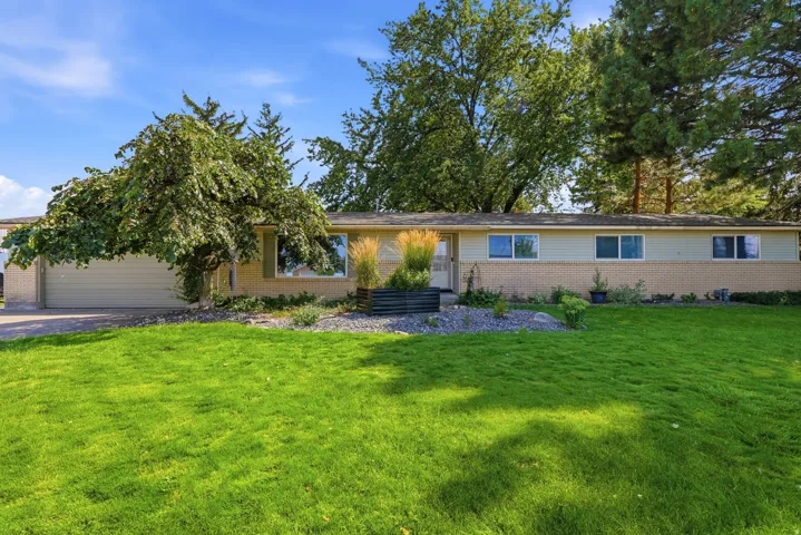 Ranch-style exterior with a light brick facade and horizontal siding