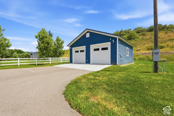 Two-car detached garage with blue siding and white garage doors