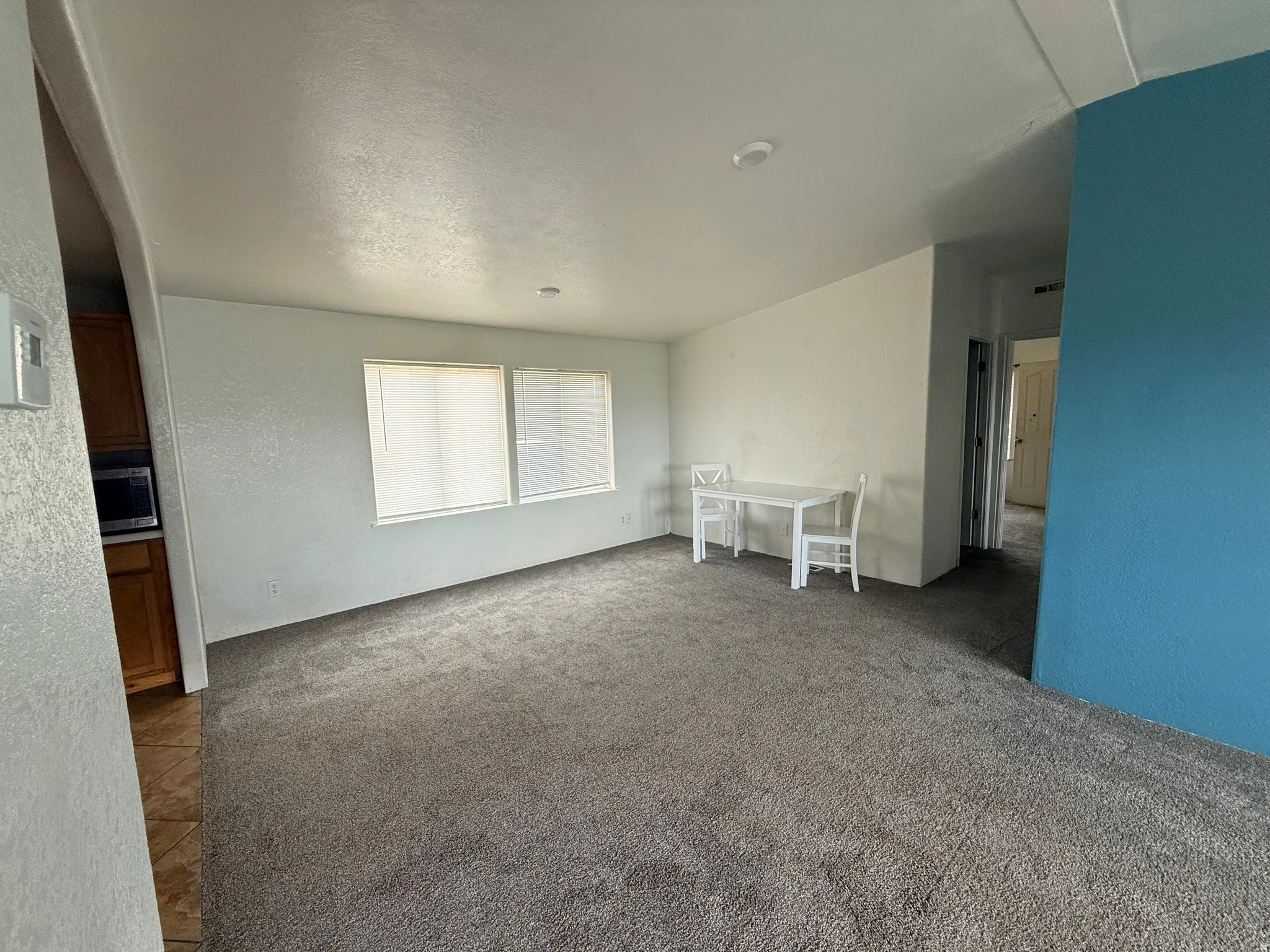 Spacious interior featuring neutral carpet, recessed lighting, and dual windows
