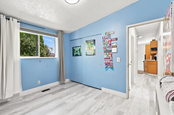 Wood-finish flooring, a window with outdoor scenery, and a ceiling-mounted light fixture