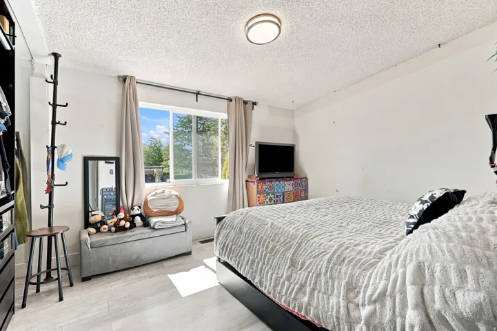 Vinyl plank flooring, large window with natural light, and ceiling-mounted light fixture