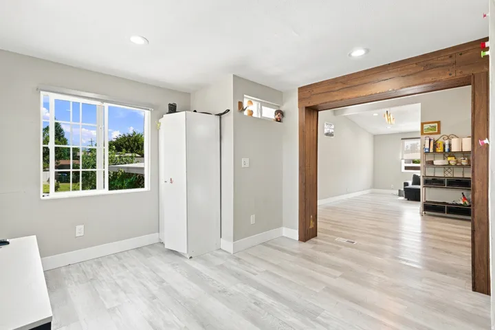 Recessed lighting, wood-finish flooring, and a wide window with grilles