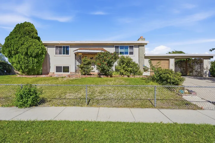 Split-level residence featuring a covered entry, attached garage, and a carport
